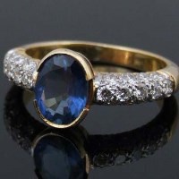 Lot 375 - Sapphire and diamond ring, the oval cut coloured