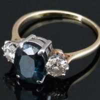 Lot 383 - Sapphire and diamond three stone ring.